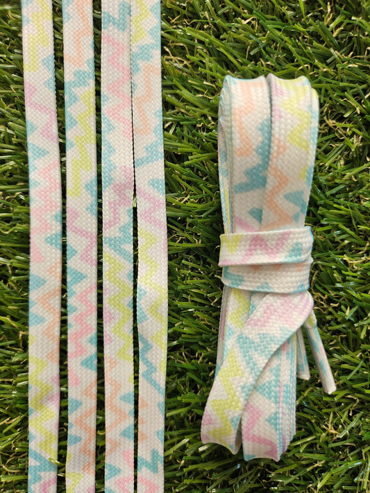 Pastel zigzag patterned shoelaces laid flat and styled in a white trainer
