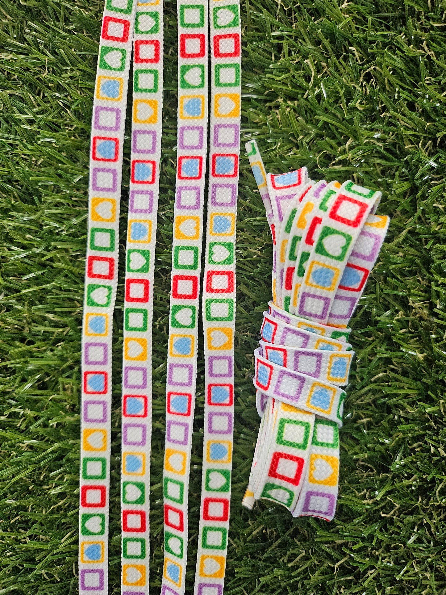 Rainbow patterned shoelaces with colourful shapes on white background