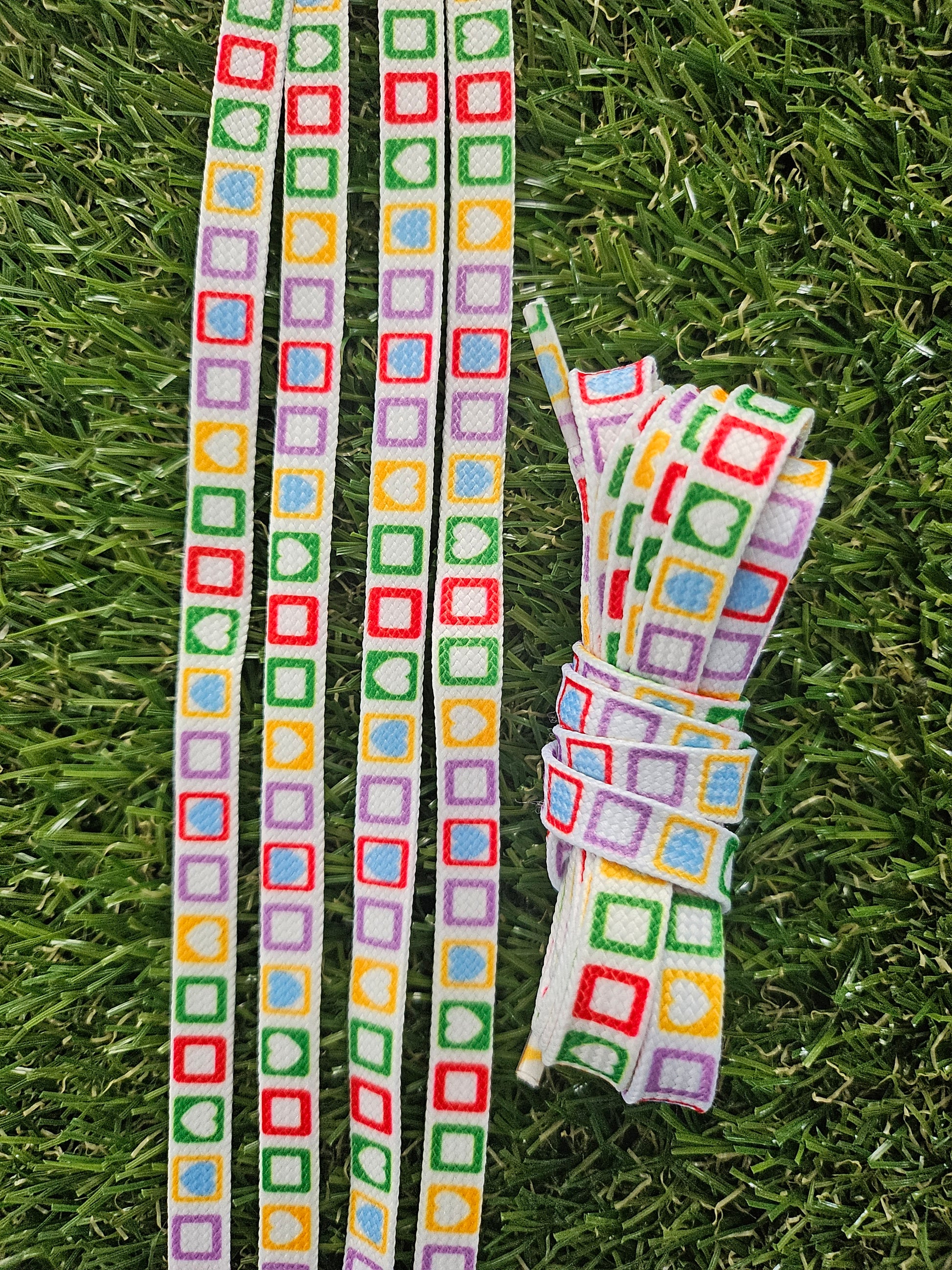 Rainbow patterned shoelaces with colourful shapes on white background